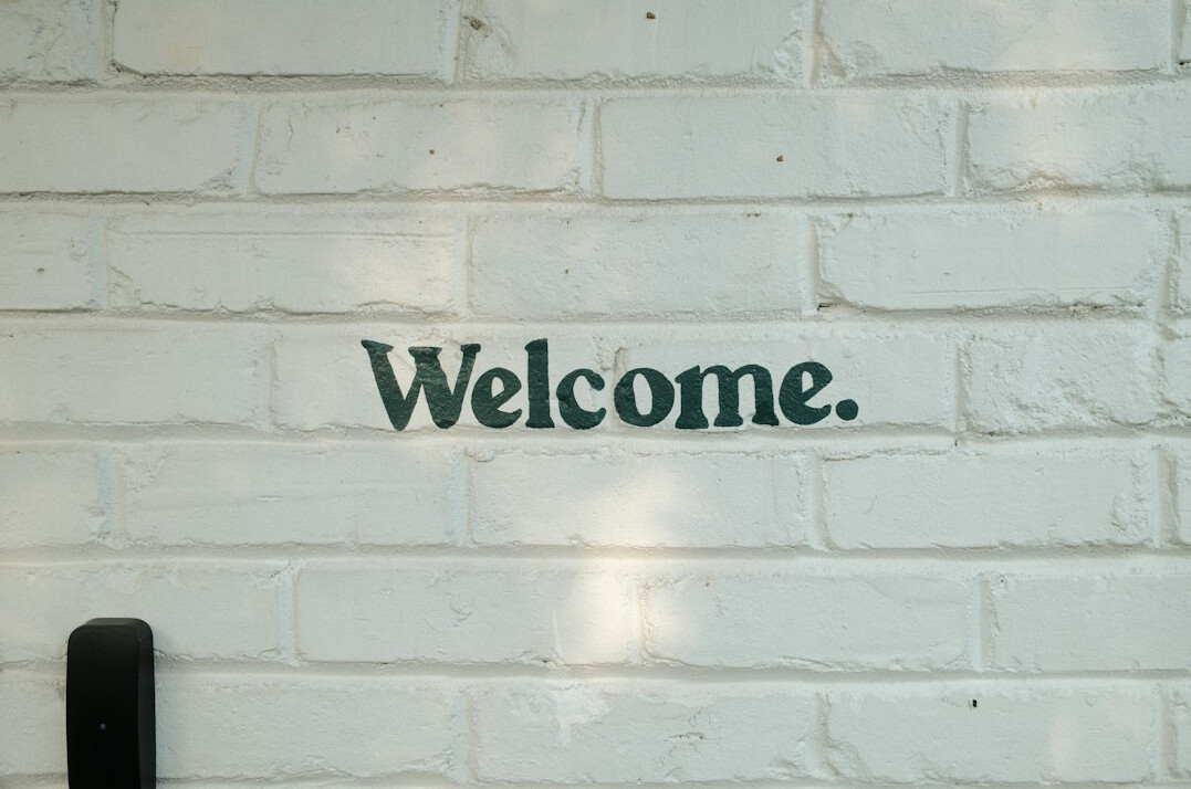 Friendly volunteer welcoming an elderly visitor at the club entrance