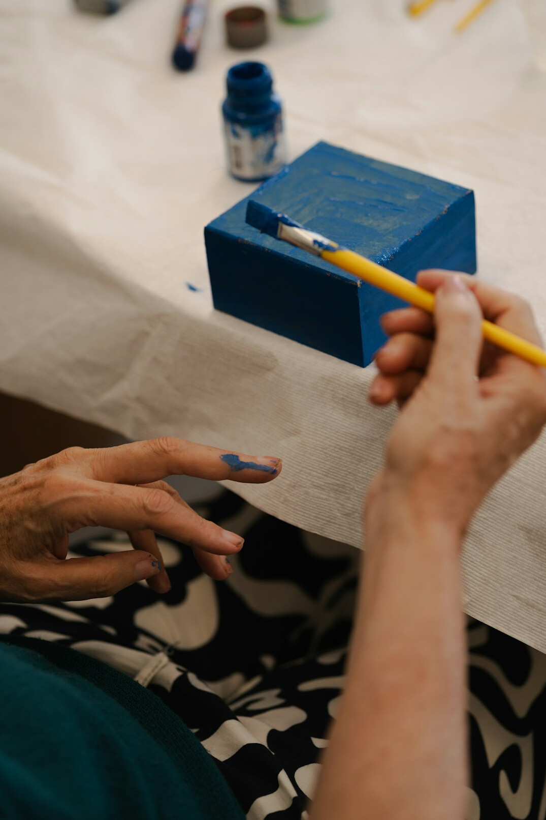 Seniors painting and crafting together at a creative workshop
